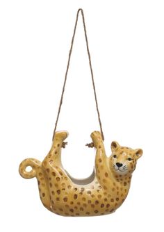 a ceramic hanging ornament with a cheetah on it's back