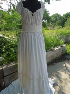 This is a sweet peasant dress made for Old Navy.  It is ankle length and has short sleeves and an elastic waist.  It has a bow tie at the bodice. The size says it's a Large.  It is cotton and it is lined (to the top of the bottom ruffle). Measurements: Shoulder to hem: 48 1/2" Shoulder to shoulder: 11" Waist: 15" (is stretchy) Hips: full Underarm to underarm: 17" Neck to top of elastic waist band: 8" Neck to bottom of elastic waist band: 11 1/2" All my items come from my smoke-free home however because they are vintage they have a prior history I know nothing about.  It is not uncommon for items to show some signs of wear.  I carefully inspect each item and give you an accurate and informed description as much as possible.  If I make repairs I let you know.  If there are rips or stains I a Summer Prairie Dress With Ruffles For Gatherings, Summer Prairie Dress With Smocked Bodice For Gatherings, Summer Cotton Peasant Prairie Dress, Summer Cotton Prairie Peasant Dress, Summer Cottagecore Prairie Dress For Gatherings, Spring Peasant Dress For Garden Party, Cottagecore Short Sleeve Maxi Dress For Summer, Cottagecore Short Sleeve Summer Maxi Dress, Spring Peasant Prairie Dress