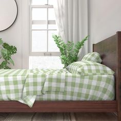 a bed with yellow and white checkered bedspread in front of a window