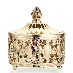 a golden metal box with an ornate design on the front and sides, sitting on a white surface