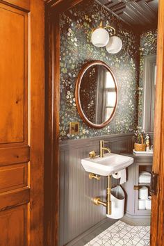 a bathroom with a sink, mirror and toilet paper dispenser in it