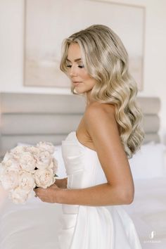 a woman in a white dress holding a bouquet of flowers