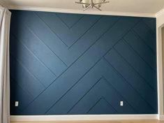 an empty room with blue painted walls and wood floors