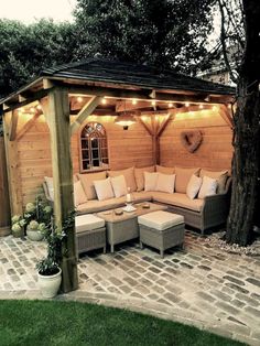 an outdoor living area with couches and lights on the roof, surrounded by brick pavers