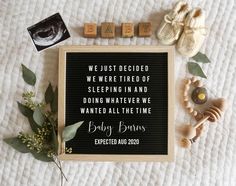 baby shoes and scrabbles laid out next to a sign that says, we just decided we were tired of sleeping in and doing whatever we wanted all the time