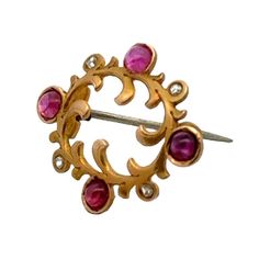 This delicate Art Nouveau brooch is crafted in 14 karat yellow gold and features a graceful design adorned with sparkling rose cut diamonds and vibrant cabochon rubies. The flowing lines and organic motifs characteristic of the Art Nouveau era are beautifully highlighted in this dainty piece, making it a charming blend of elegance and artistic craftsmanship. The brooch measures .75 x 1.00 inches. Weight: 2.3 grams. Art Nouveau Rose, Emerald Dragon, Sparkling Rose, 20th Century Art, Art Nouveau Antiques, Gold Brooch, Antique Brooches, Ruby Stone, Gold Brooches