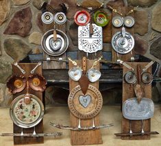 an assortment of metal and wood items on display in front of a stone fireplace mantel