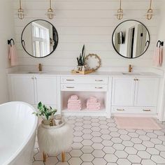 a bathroom with two round mirrors above the bathtub