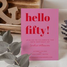 a pink birthday party card with the words hello fifty printed on it next to some plants