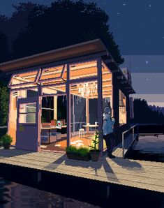 a person standing on a dock next to a small house at night with the lights on