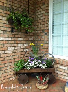 some flowers and plants are in pots on a cart outside the front of a house