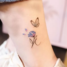 a small tattoo on the ankle of a woman's foot with flowers and butterflies