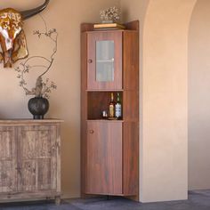 a tall wooden cabinet sitting next to a wall