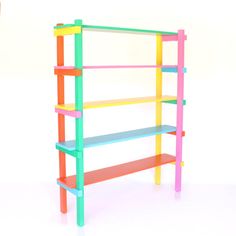 a multicolored book shelf sitting on top of a white floor