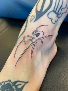 a person's foot with a spider tattoo on it