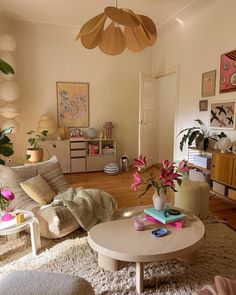 a living room filled with lots of furniture and flowers on top of a coffee table