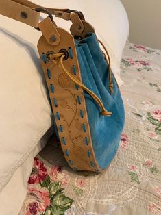 a blue purse sitting on top of a bed