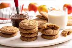 cookies and milk on a plate with apples in the background