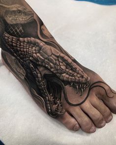 a foot with a snake tattoo on it