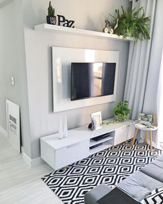 a modern living room with white furniture and black and white rugs on the floor