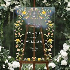 an easel is adorned with flowers and greenery for a wedding sign that reads, welcome to the wedding of amanda and william