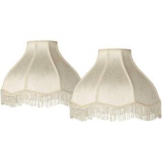 two white lamps with fringes on them