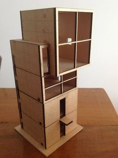 a cardboard model of a house on top of a wooden table