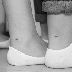 two people with small tattoos on their legs, one has the words we are in cursive writing