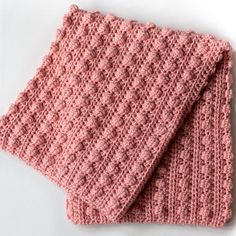 a pink knitted dishcloth on a white surface