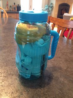 a blue mason jar filled with different types of items on top of a kitchen counter