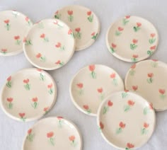 six small plates with flowers painted on them