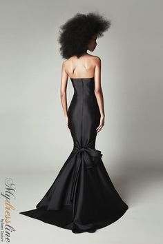 a woman in a black dress with an afro