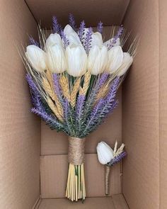 a bouquet of white and purple flowers in a cardboard box