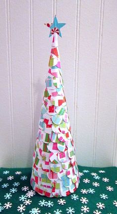 a paper christmas tree sitting on top of a table