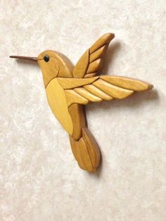 a wooden hummingbird ornament hanging on a wall