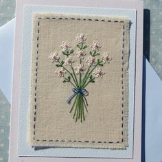 a greeting card with white flowers and blue ribbon