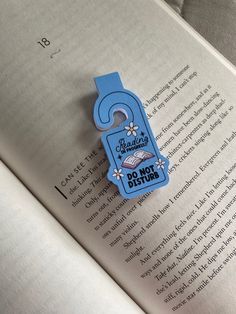 a blue bookmark that says do not disturb on it in front of an open book