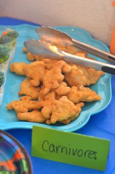 a blue plate with broccoli and other foods on it next to a spoon