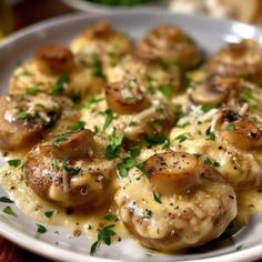 a white plate topped with mushrooms covered in gravy