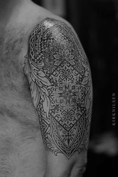 black and white photo of a man's arm with an intricate tattoo design on it