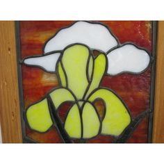 a stained glass window with a flower on it's side and an orange background