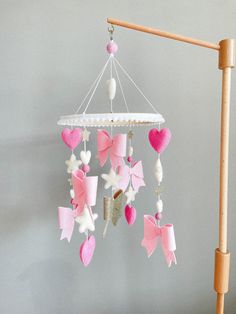 a pink and white mobile with hearts hanging from it