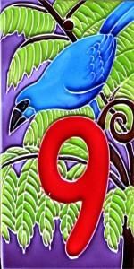 a blue bird sitting on top of a green tree next to the number nine sign