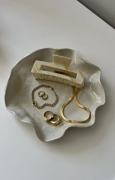 a white plate with gold jewelry on it