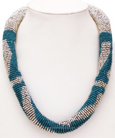 Fashion necklace with blue and silver beads on a flexible wicks thread. The beads are hand-strung. The necklace measures 18 inches and ties at the back with a hook for sizing flexibility. The ensembled look of these colors is great to go with dresses of any one or a mixture of these colors, to give a classy look. Length 18 inches. Turquoise Polished Beads Necklace For Party, Turquoise Beaded Necklaces With Large Beads For Party, Blue Jewelry With Silver Metal Beads, Blue Necklace With Round Silver Beads, Blue And Silver Beads For Jewelry Making, Adjustable Blue Beaded Necklace With Silver Beads, Silver Choker With Colorful Round Beads, Blue Choker With Large Round Beads, Beads Fashion