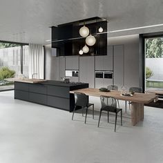 a modern kitchen with an island and dining table in the center, surrounded by large windows