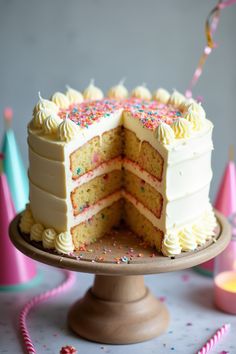 a cake with white frosting and colorful sprinkles on it's side