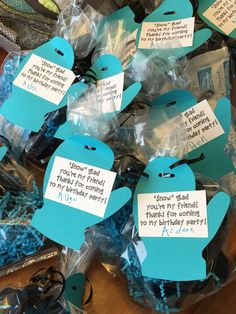 blue and white cupcakes with tags on them sitting in plastic wrapper bags