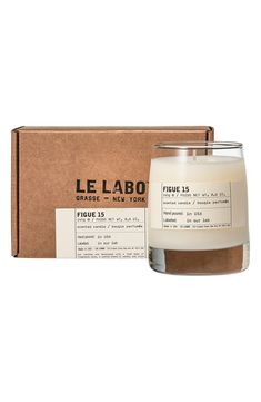 a candle in front of a box with the label for le labo on it