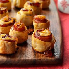 small pastries are arranged on a wooden cutting board